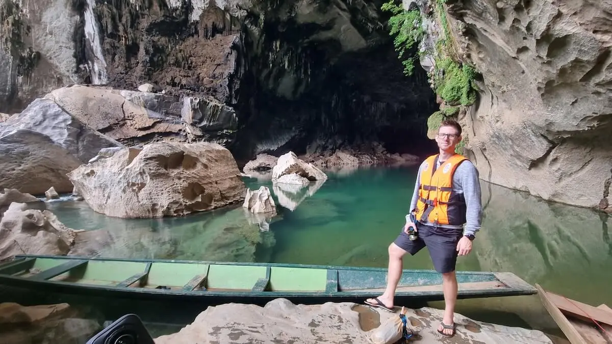 xe bang fai river cave entrance man with wooden boat