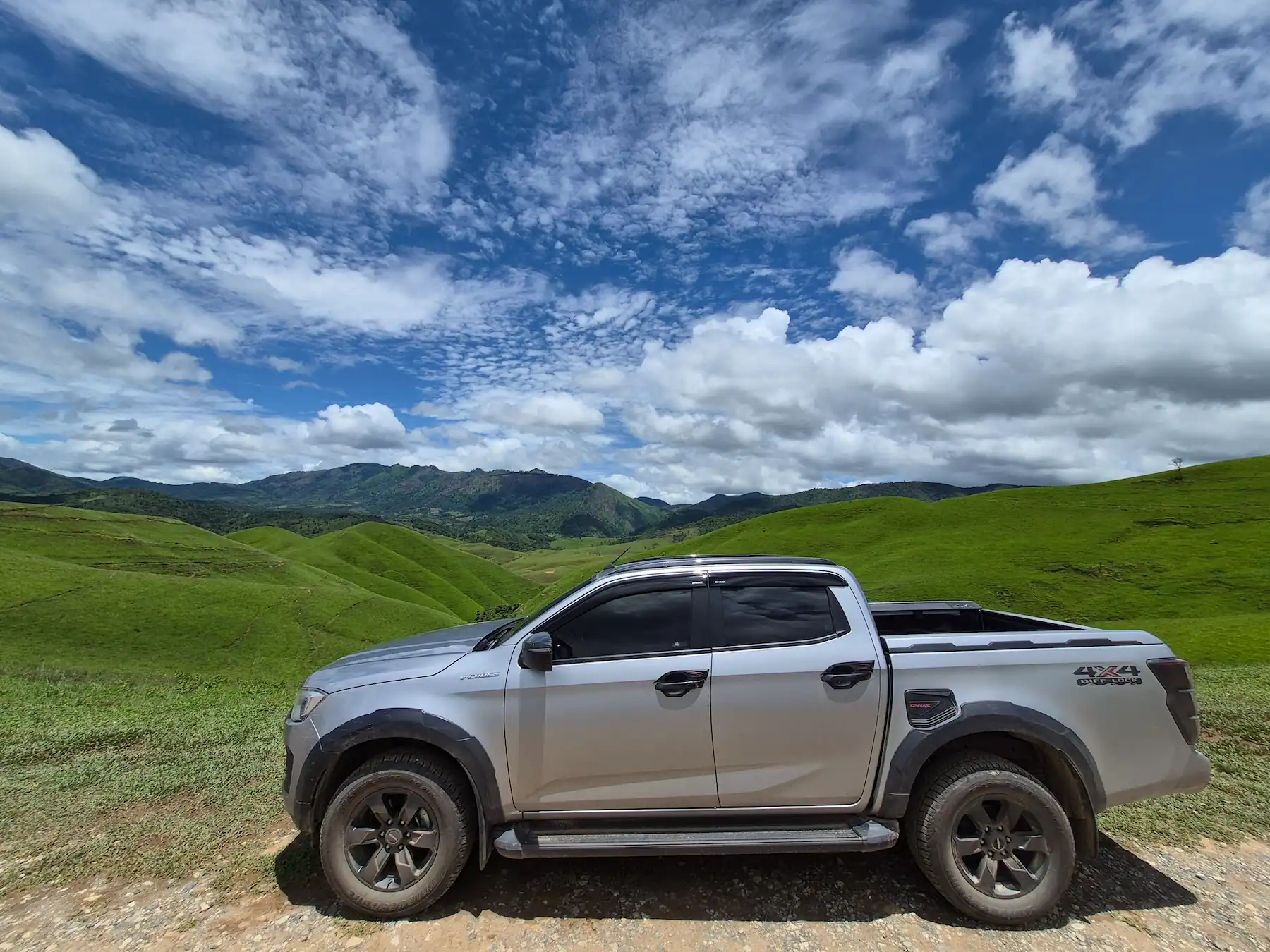 4x4 pickup parked among the green hills of Phou Hua Lon in Laos